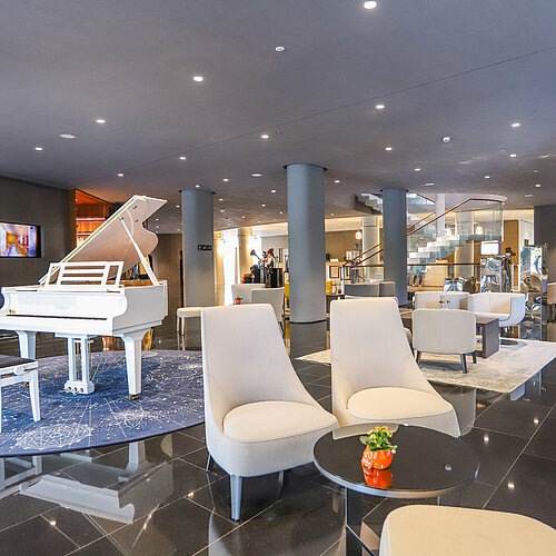 Elegante Hotellobby mit weißem Flügel und stilvollen Sitzgruppen im Maritim Hotel Plaza Tirana