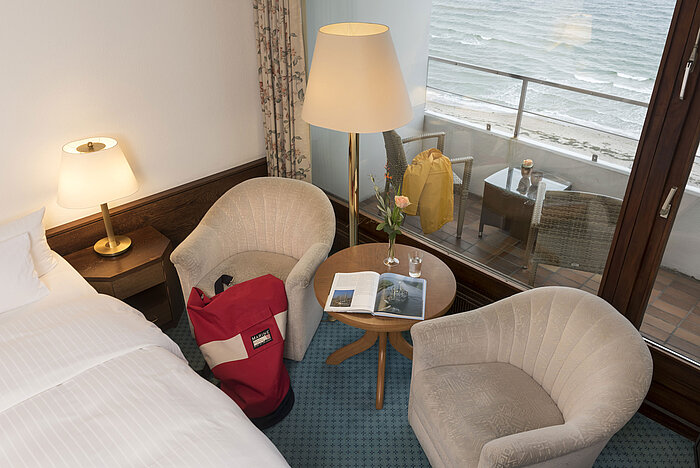 Sitzbereich mit zwei Sesseln, Tisch und Balkonblick aufs Meer im Maritim Seehotel Timmendorfer Strand.