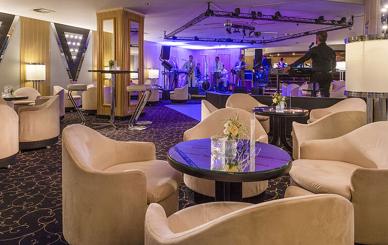 Eleganter Barbereich mit Live-Band, stimmungsvoller Beleuchtung und komfortablen Sitzgelegenheiten für Gäste.