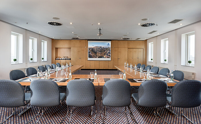 Meetingraum mit rechteckiger Tischanordnung und moderner Präsentationstechnik im Maritim proArte Hotel Berlin.