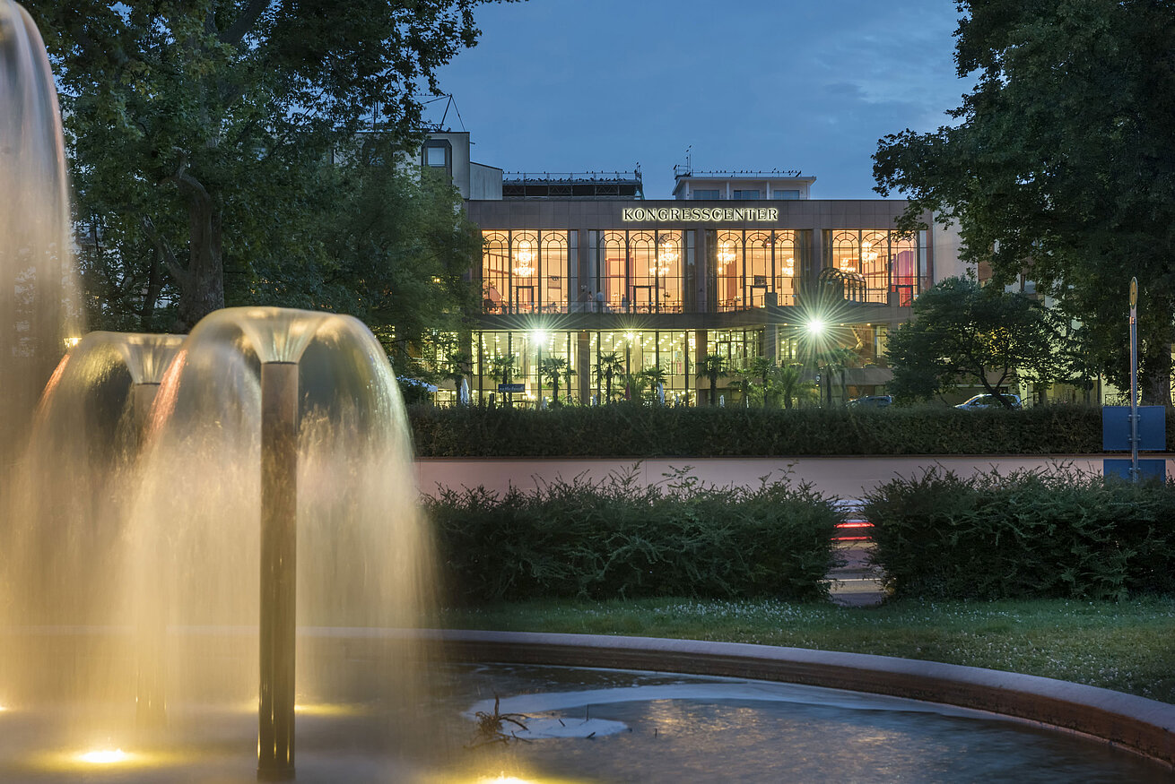 Außenansicht Kongresscenter Stimmungsvolle Abendaufnahme des Kongresscenters im Maritim Hotel Bad Homburg mit beleuchtetem Brunnen.