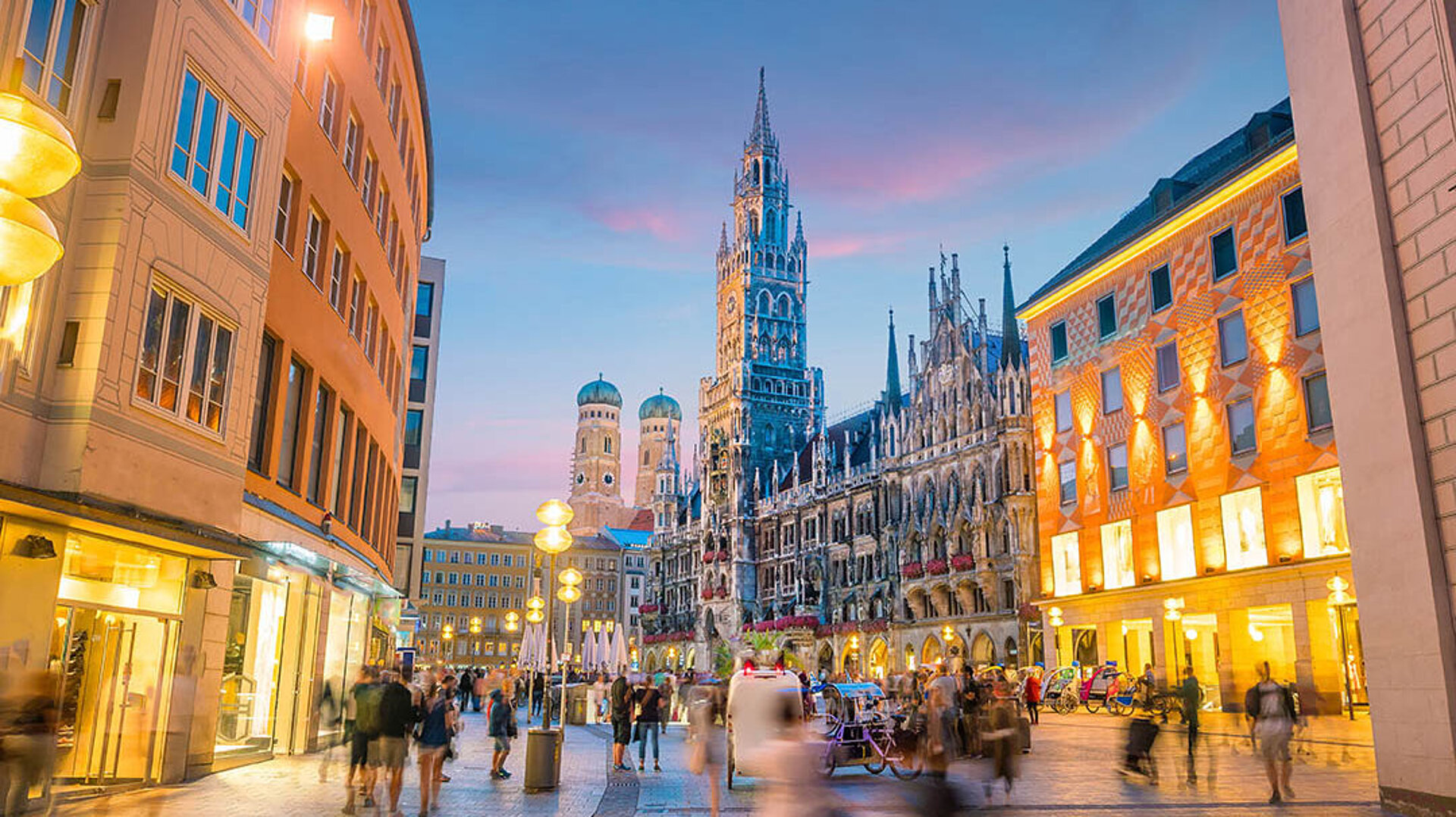 Marienplatz in München mit Neuem Rathaus, beleuchteten Gebäuden und lebendiger Innenstadt am Abend