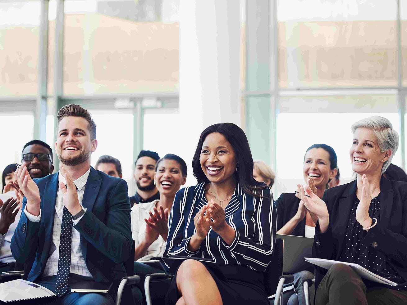 Teilnehmer applaudieren bei Konferenz oder Seminar im Tagungsraum