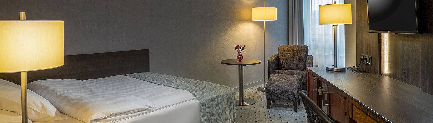 Classic Einzelzimmer Modern eingerichtetes Classic Zimmer mit Schreibtisch, Fernseher, Sitzbereich und komfortablem Bett im Maritim Bremen.