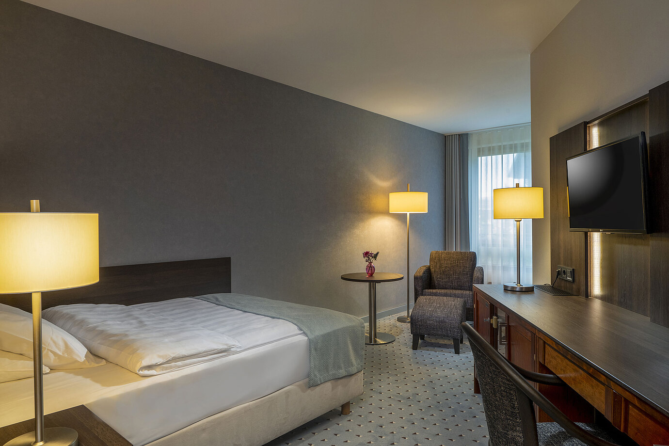 Modern eingerichtetes Classic Zimmer mit Schreibtisch, Fernseher, Sitzbereich und komfortablem Bett im Maritim Bremen.