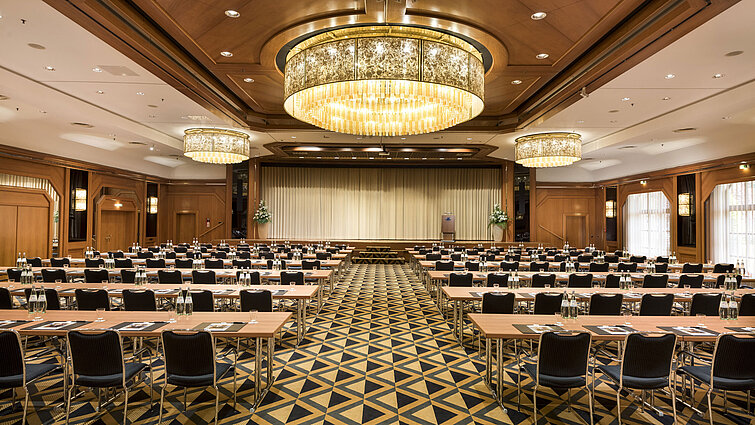 Eleganter Tagungssaal mit Bühne, Kronleuchtern und moderner Bestuhlung im Maritim Hotel Königswinter.