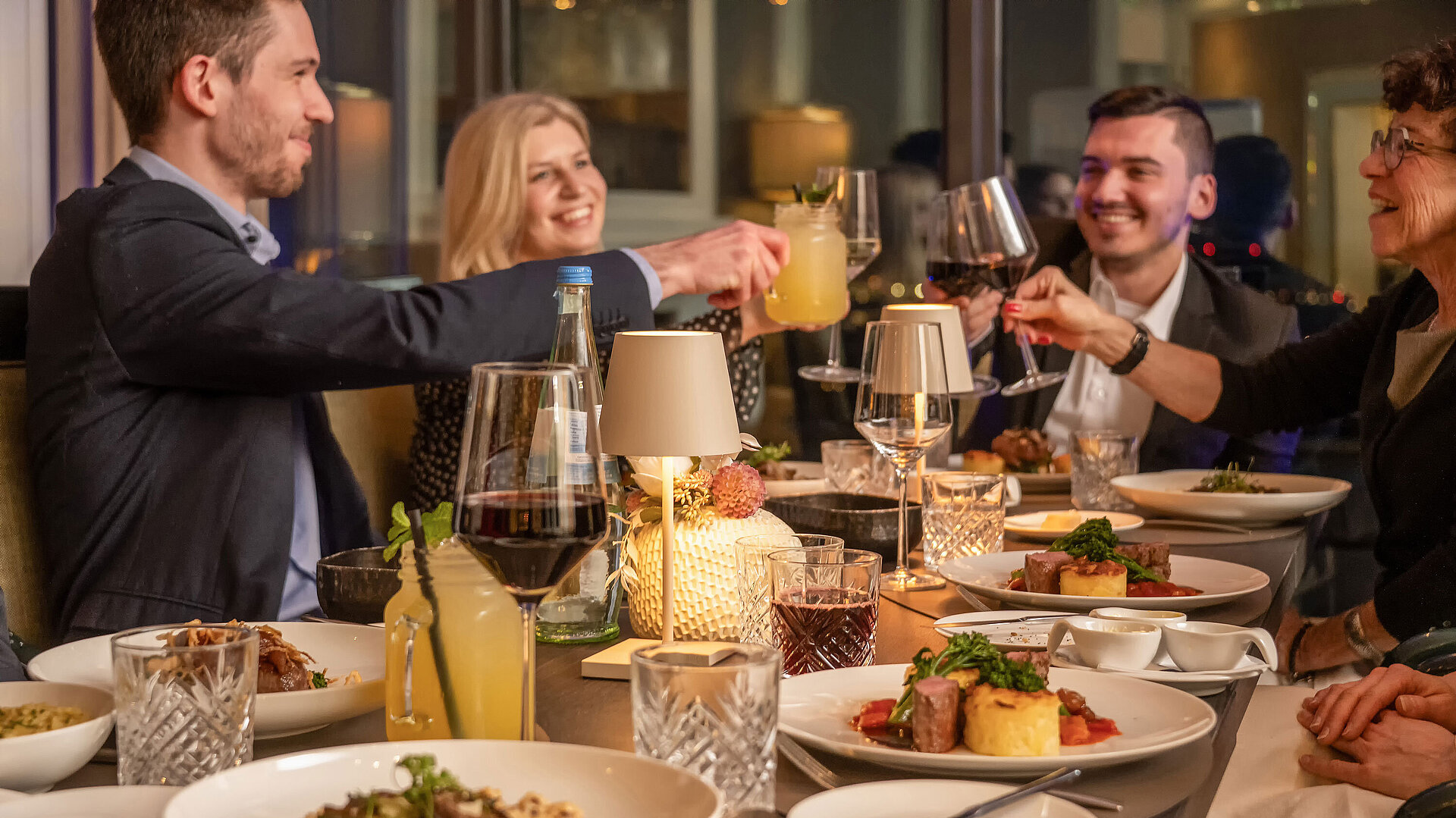 Gäste genießen ein gemeinsames Dinner im Restaurant an einem stilvoll gedeckten Tisch