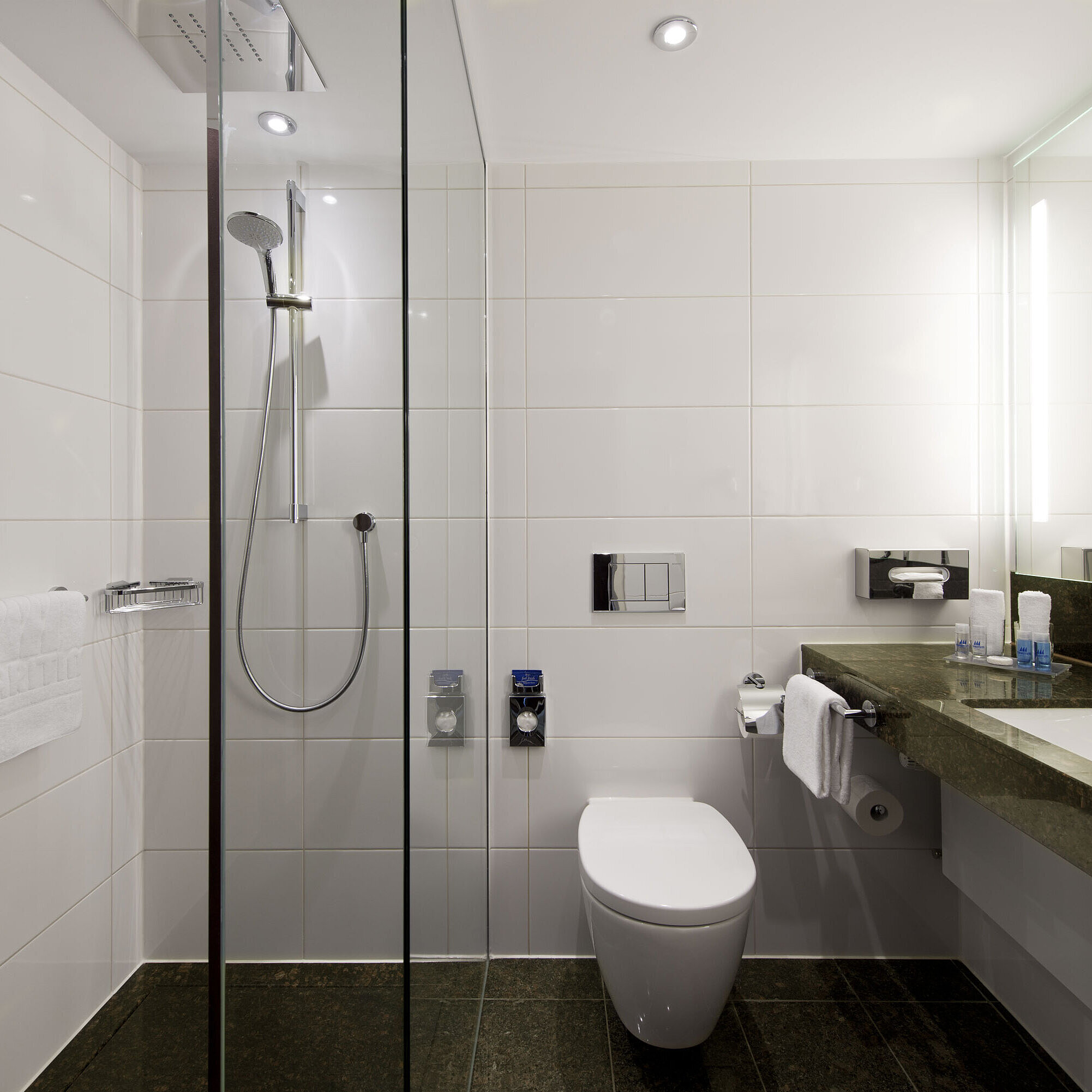 Badezimmer mit Dusche Elegantes Badezimmer im Maritim Hotel Darmstadt mit großzügiger Regendusche,moderner Einrichtung und dunkler Granitoberfläche