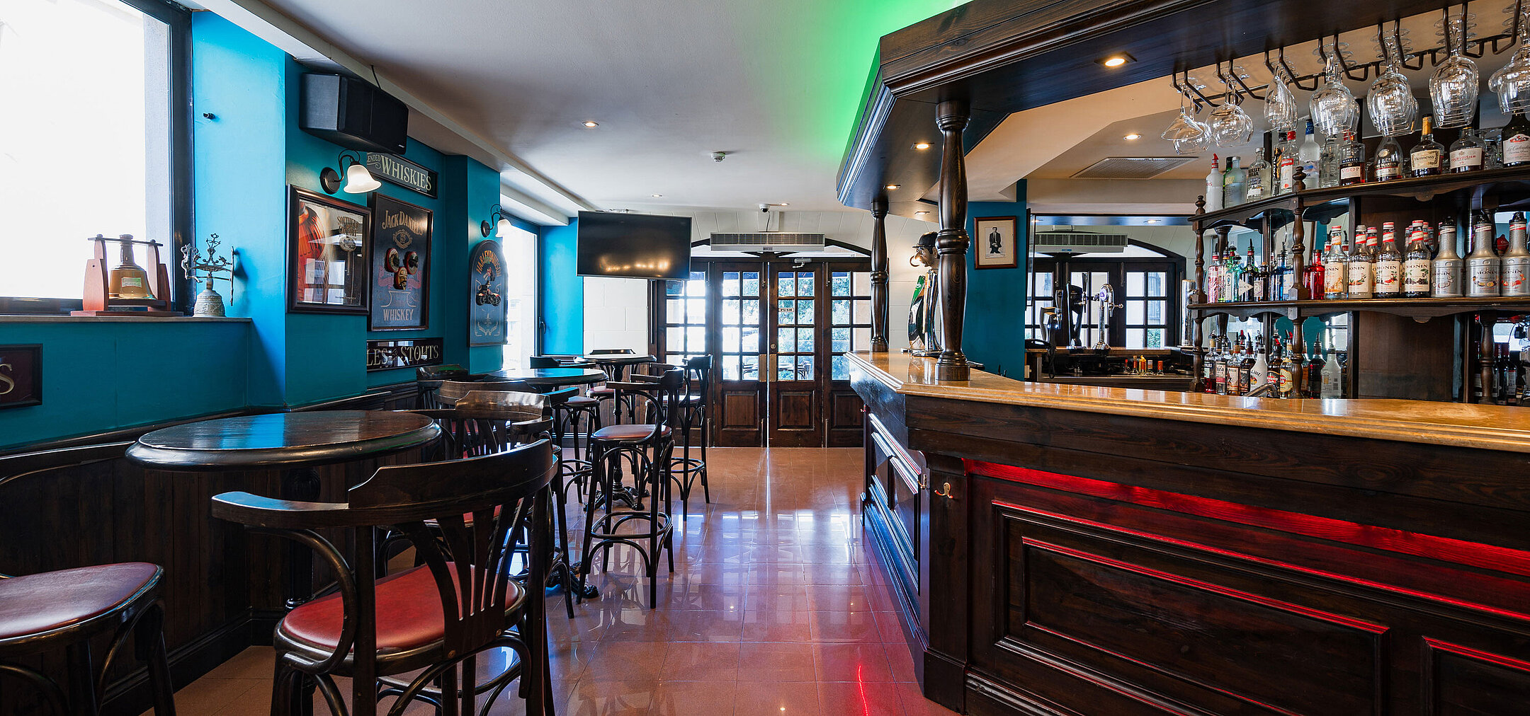 Stilvolle Pub-Bar im Maritim Antonine Hotel & Spa Malta mit dunklem Holzinterieur, Spirituosenauswahl und gemütlichen Sitzbereichen.