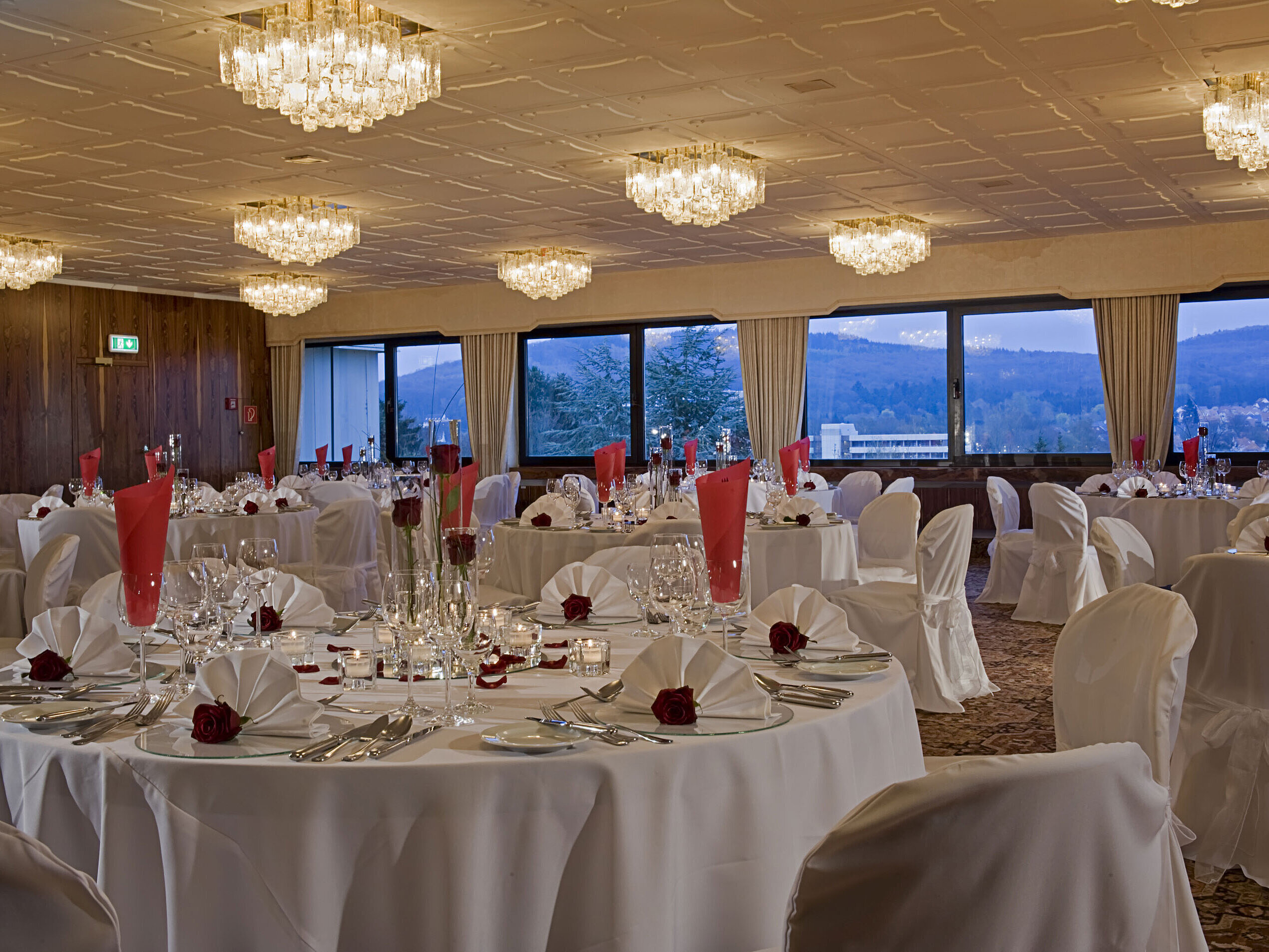 Großer Saal mit runden Tischen, eleganter Deko und Blick ins Grüne im Maritim Hotel Bad Salzuflen
