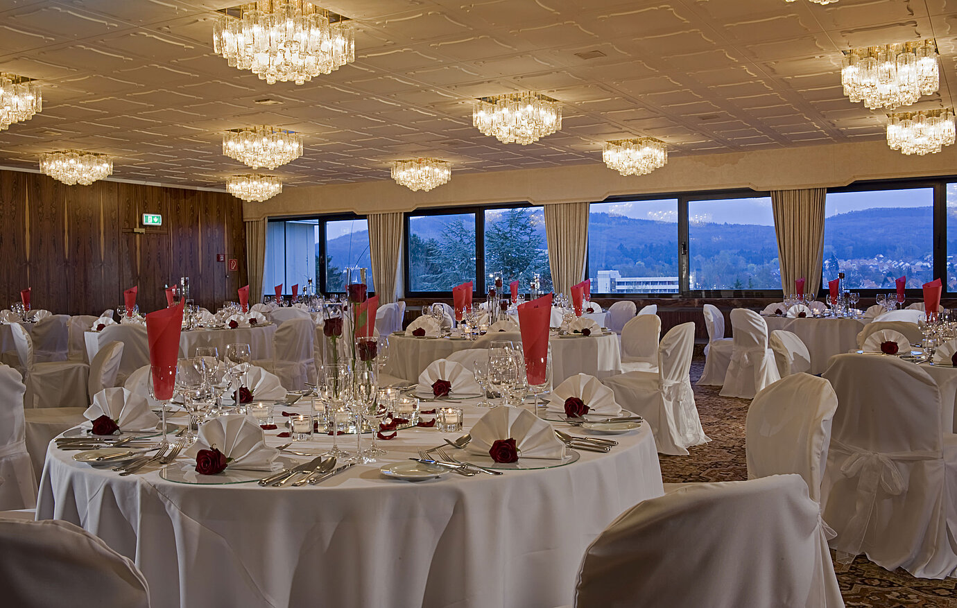 Großer Saal mit runden Tischen, eleganter Deko und Blick ins Grüne im Maritim Hotel Bad Salzuflen