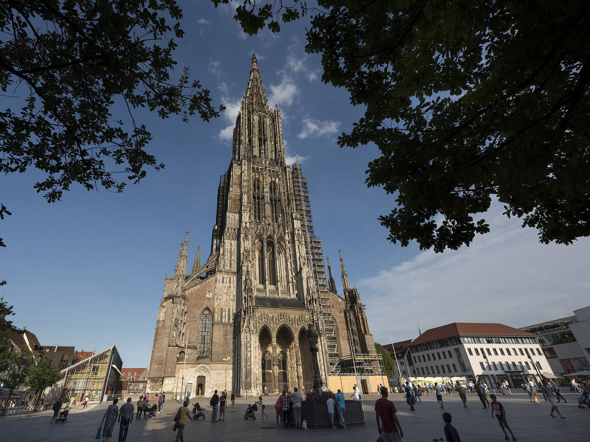 Ulmer Münster Blick auf das imposante Ulmer Münster, die höchste Kirche der Welt, mit Menschen auf dem Münsterplatz.