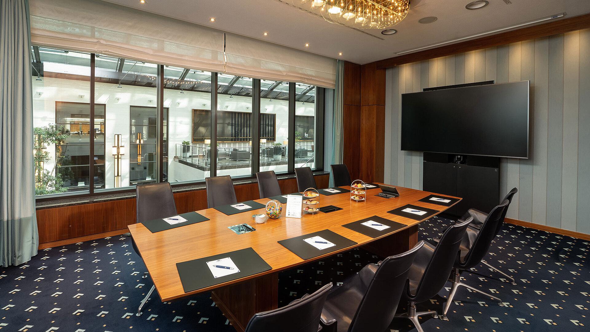 Moderner Tagungsraum im Maritim Hotel Düsseldorf mit großem Tisch und Bildschirm