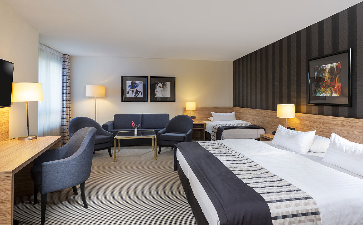 Komfortables Familienzimmer mit stilvollem Design und gemütlicher Sitzecke im Maritim Hotel Königswinter.