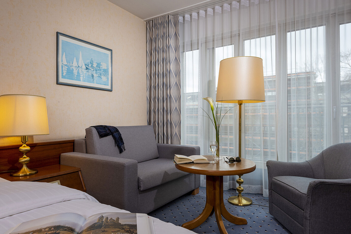 Comfort Zimmer im Maritim Hotel Köln, mit gemütlicher Sitzecke, Lesetisch und moderner Einrichtung.