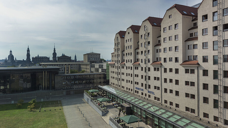 Außenansicht des Maritim Hotel Dresden mit Terrasse und Blick auf die historische Altstadt.