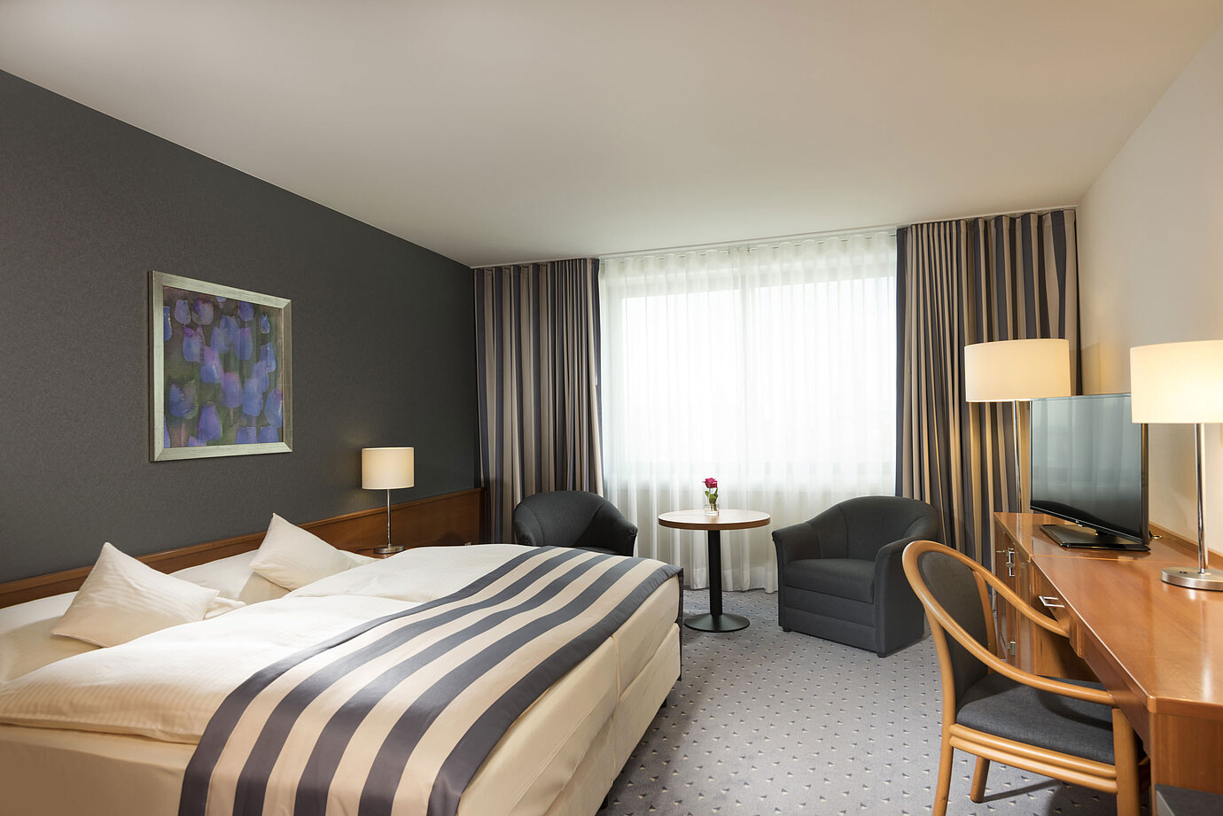 Geräumiges Doppelzimmer im Maritim Hotel Ulm mit Tageslicht, Sitzbereich und Schreibtisch