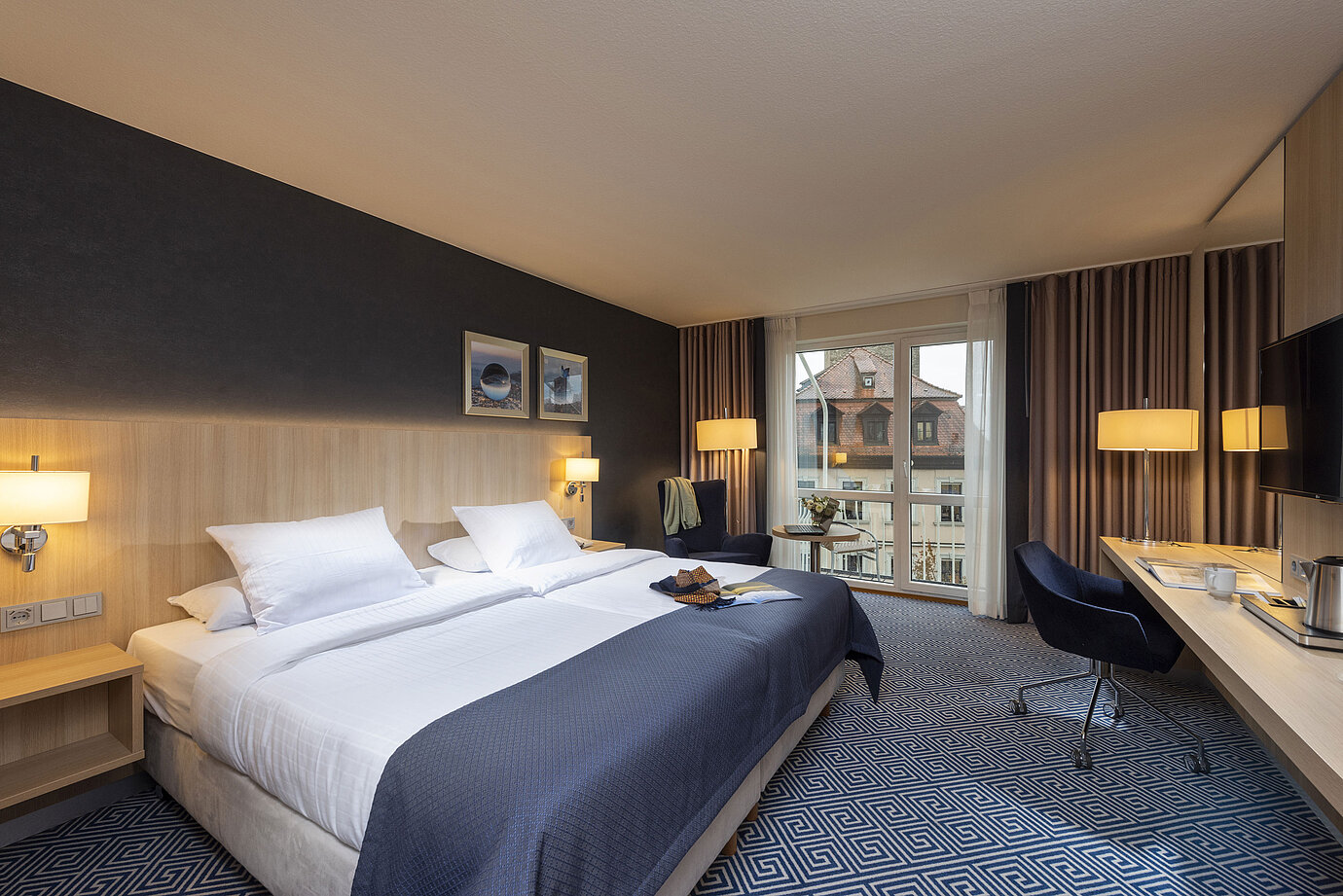 Elegantes Superior Zimmer im Maritim Hotel Würzburg mit großem Doppelbett und Ausblick auf historische Dächer