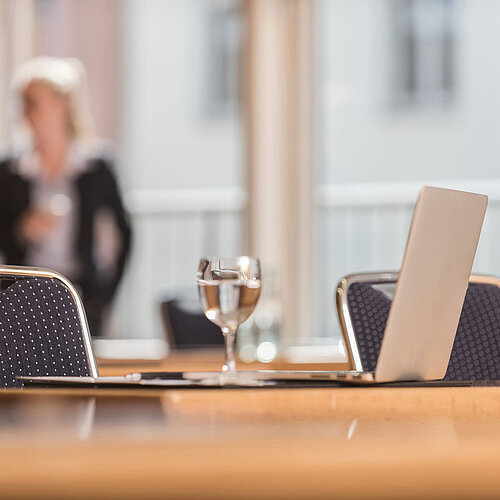  Detailansicht eines Konferenzraums im Maritim proArte Hotel Berlin mit Fokus auf Laptop und Wasserglas.