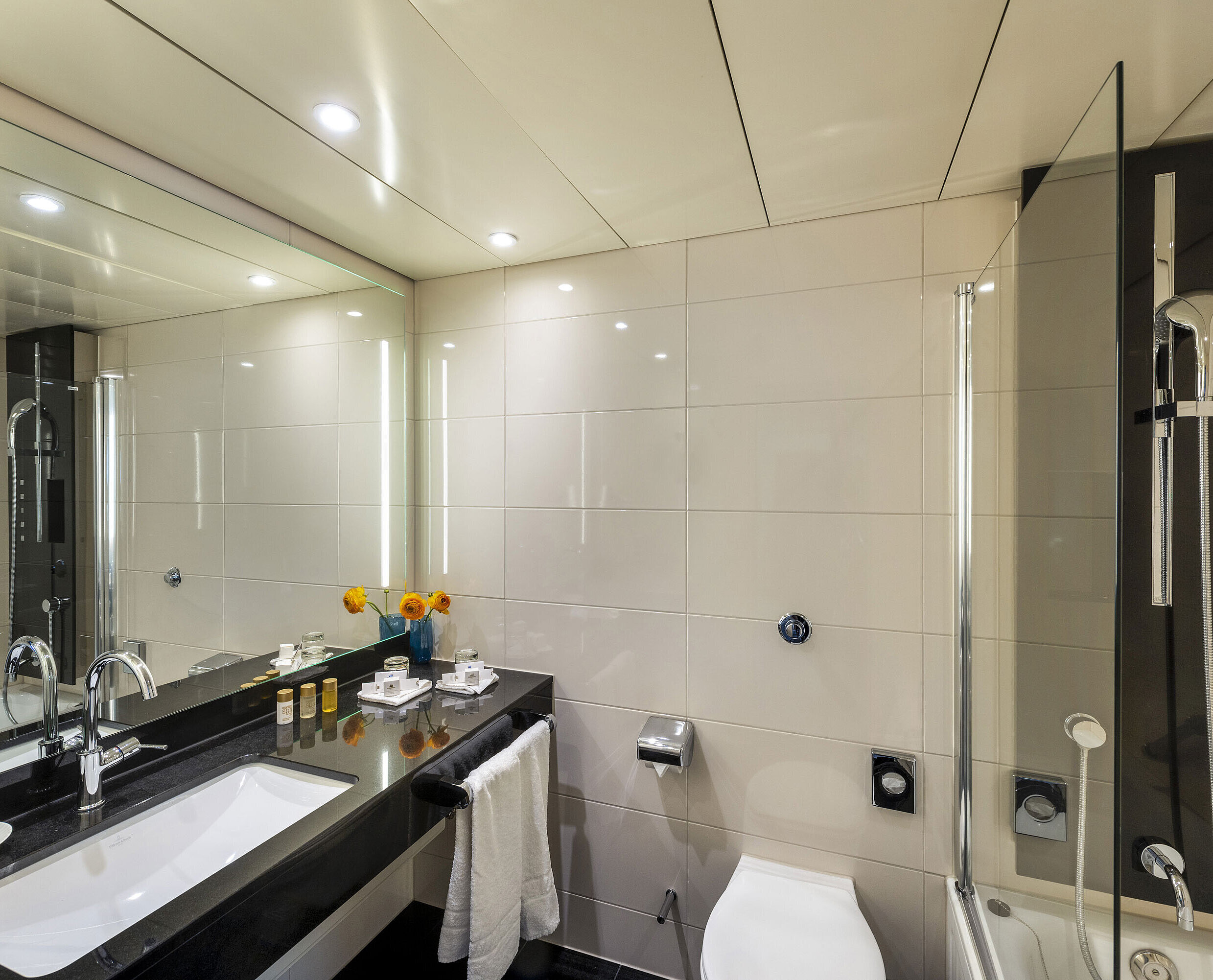 Modernes Badezimmer mit Badewanne, großem Spiegel, eleganter Armatur und hochwertigen Annehmlichkeiten im Maritim Hotel Ulm.