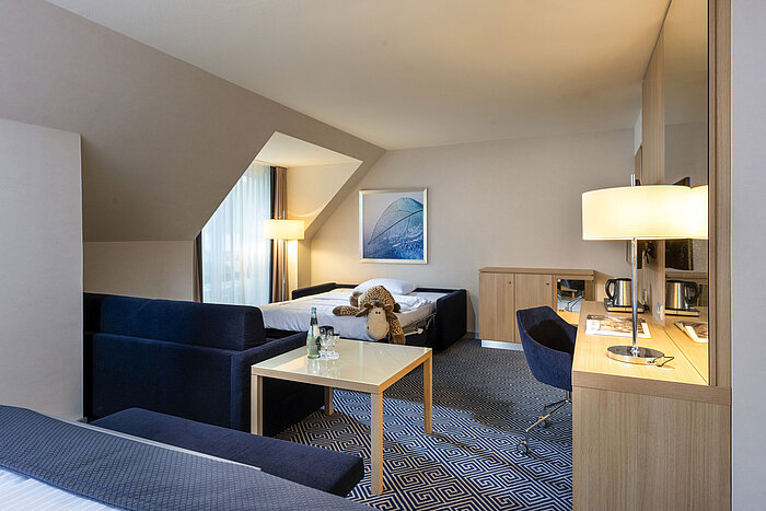 Schönes, großes Superior Familienzimmer mit Tisch, Couch und viel Licht.