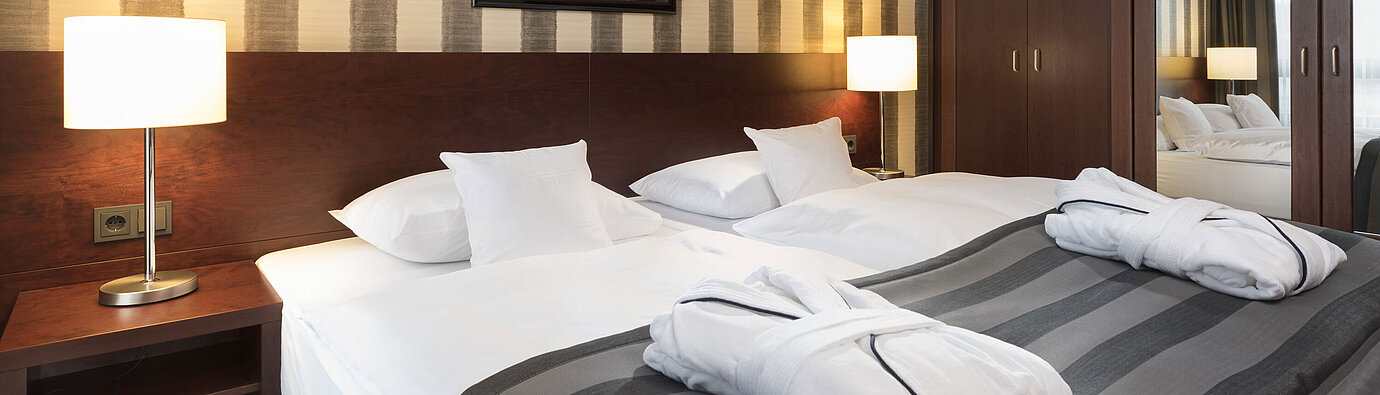 Junior Suite Modernes Doppelzimmer mit gemütlichem Bett, Bademänteln und stilvollem Interieur im Maritim Hotel Königswinter.