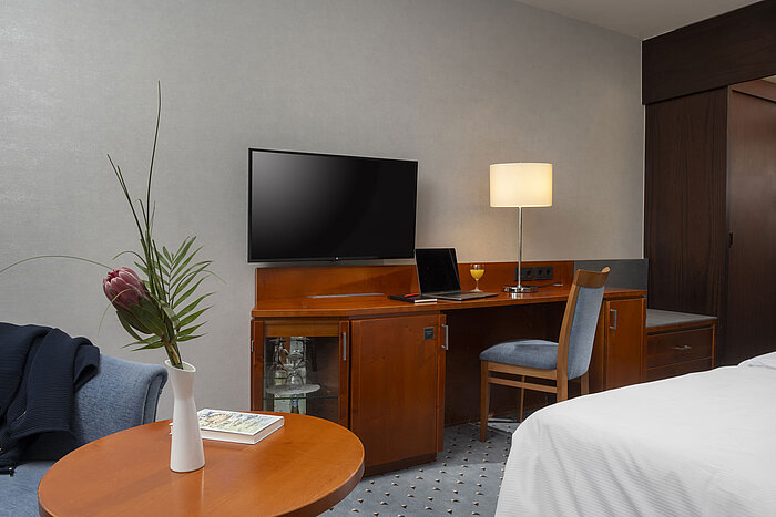  Arbeitsbereich im Classic-Zimmer des Maritim Hotel Darmstadt mit Schreibtisch, TV und moderner Einrichtung.
