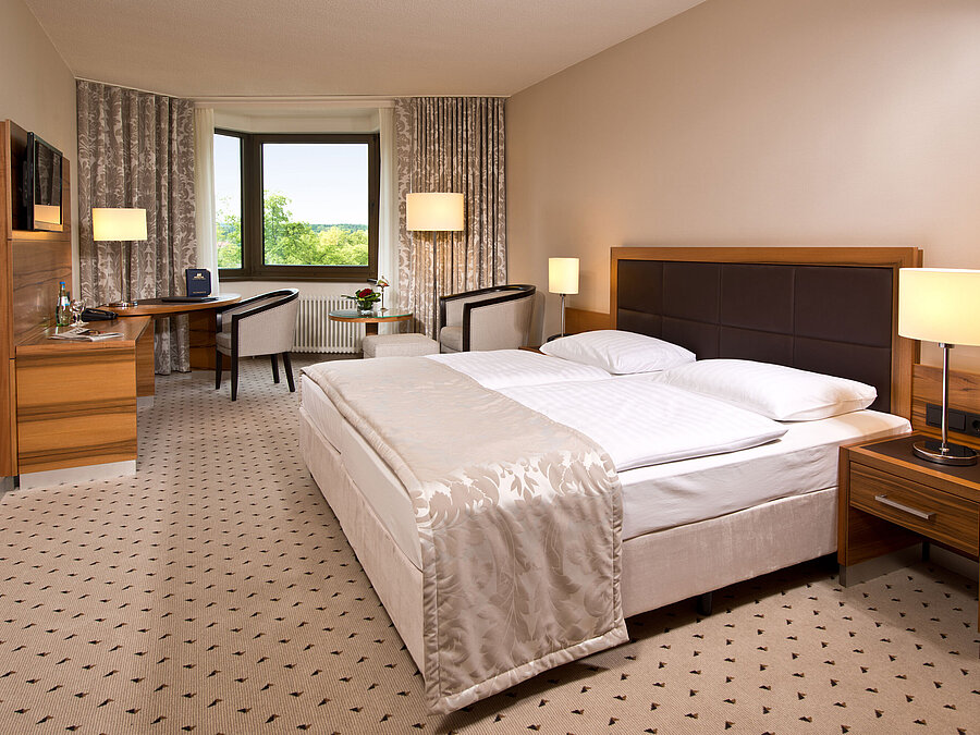 Komfortables Hotelzimmer im Maritim Hotel Bad Homburg mit modernem Design und Blick ins Grüne.
