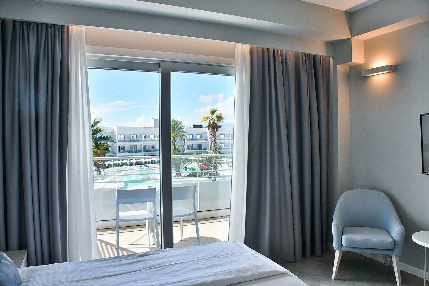 Modernes Hotelzimmer mit Balkon und direktem Blick auf den Pool im Maritim Resort Calabria