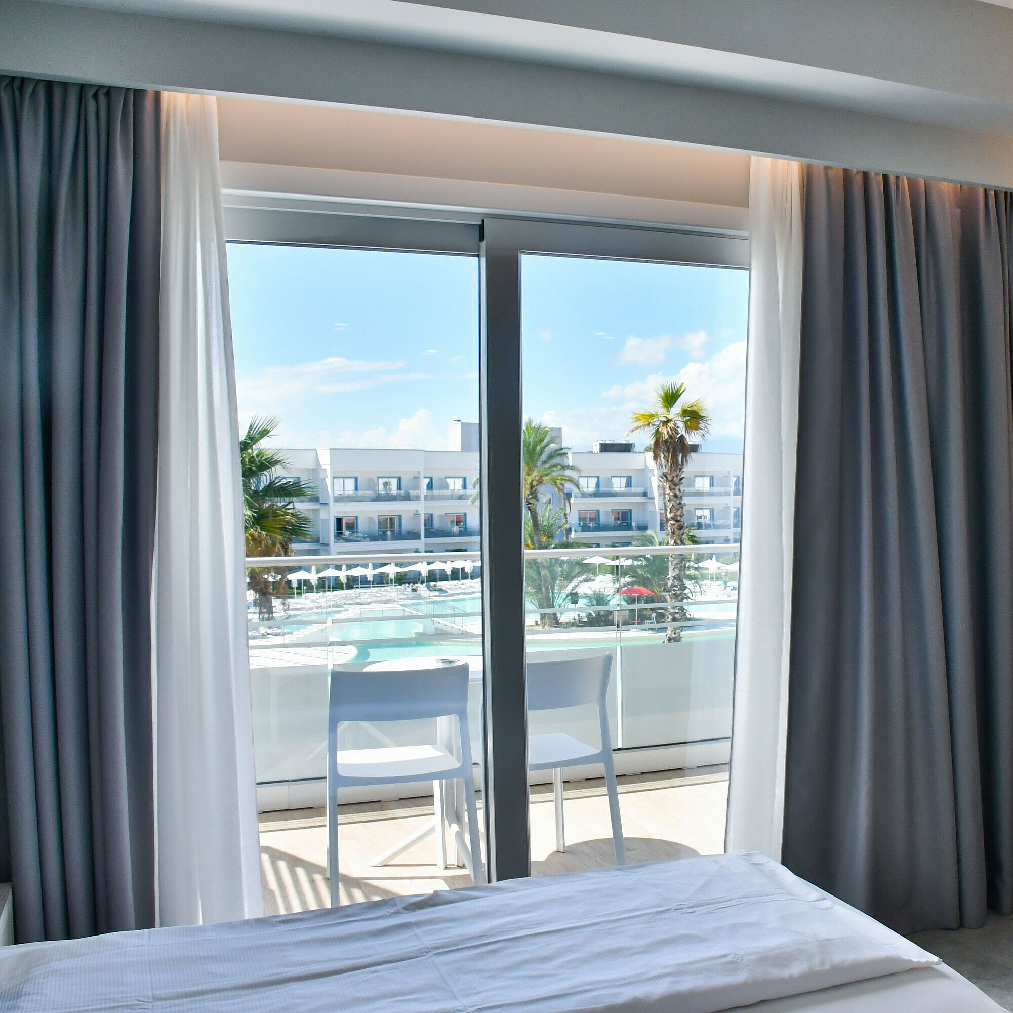 Poolblick Zimmer Modernes Hotelzimmer mit Balkon und direktem Blick auf den Pool im Maritim Resort Calabria