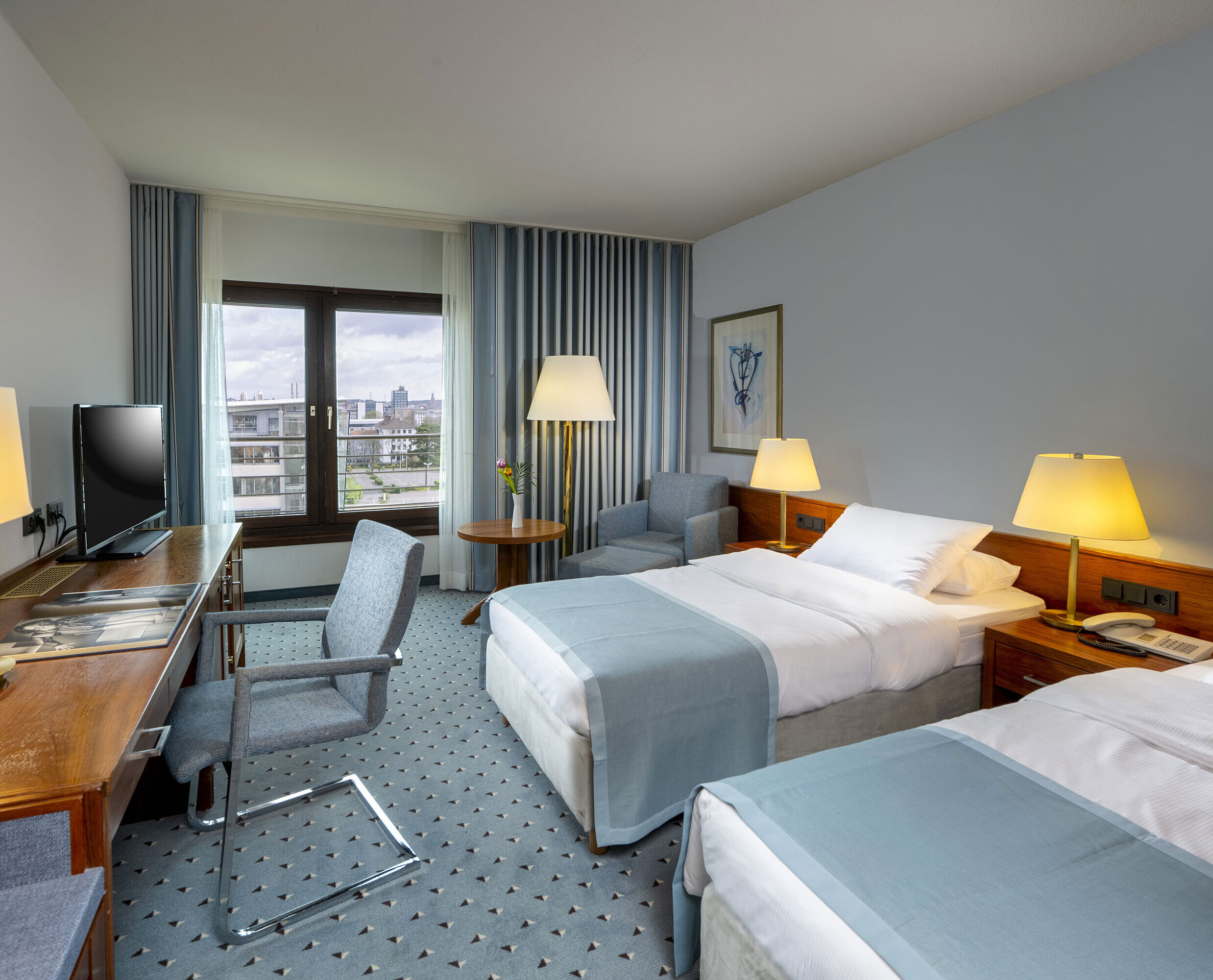 Comfort Zimmer Comfort Twin Zimmer im Maritim Hotel Darmstadt mit Schreibtisch, zwei Einzelbetten und Panoramafenster mit Stadtblick.