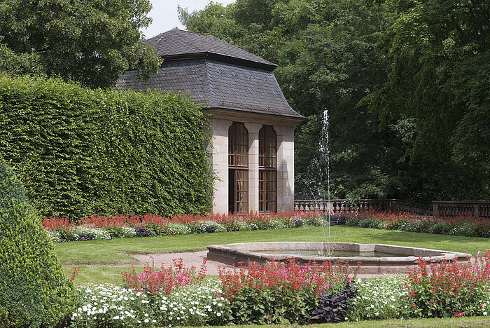 Historischer Pavillon im blühenden Garten des Maritim Hotel Fulda mit Wasserspiel und Springbrunnen.