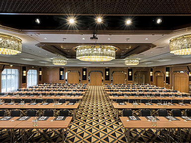 Eleganter Tagungssaal mit Bühne, Kronleuchtern und moderner Bestuhlung im Maritim Hotel Königswinter.