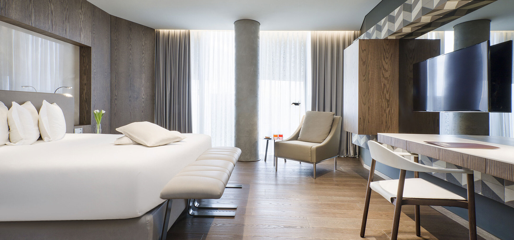 Helles Zimmer im Maritim Hotel Plaza Tirana mit Schreibtisch, großem Bett und Holzfußboden