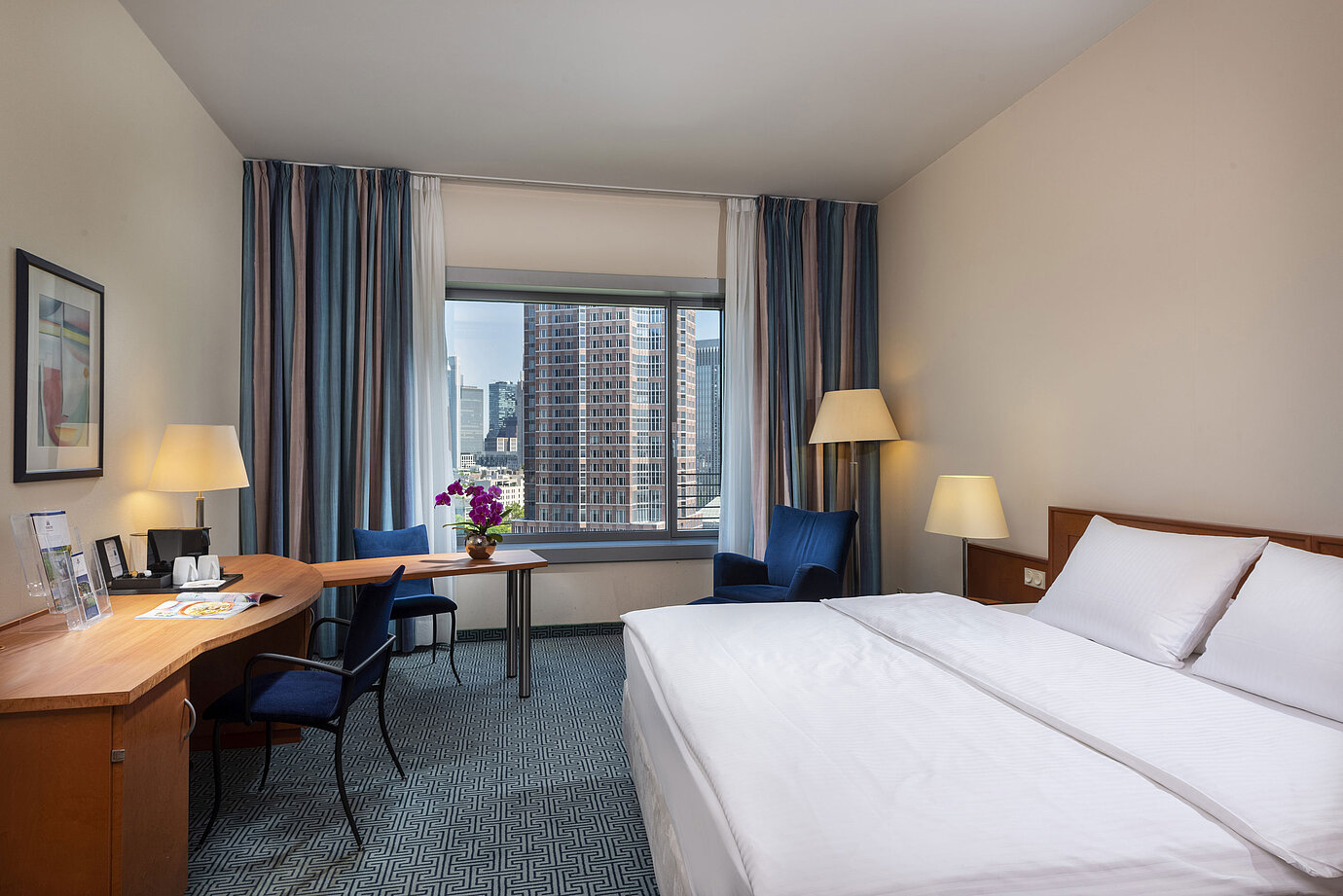 Superior Zimmer im Maritim Hotel Frankfurt mit Doppelbett, Schreibtisch und Blick auf die Frankfurter Skyline.
