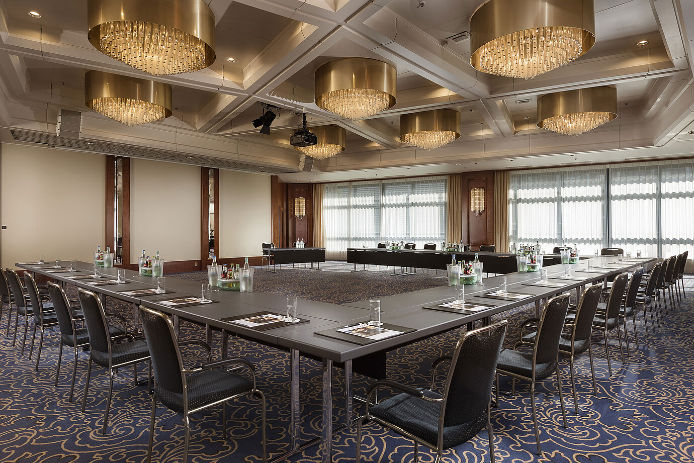 Eleganter Konferenzsaal mit U-förmiger Bestuhlung, edlen Kronleuchtern und moderner Tagungsausstattung im Maritim Hannover.
