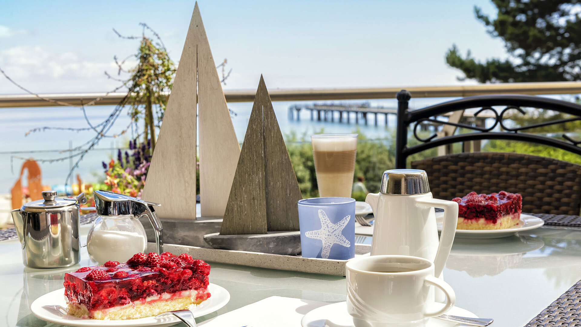 Seeterrassen-Restaurant mit Ostseeblick Kaffeetafel mit Kuchen und Heißgetränken auf der Terrasse des Maritim Seehotel Timmendorfer Strand mit Meerblick.