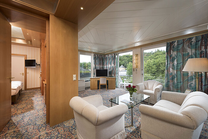 Geräumige Suite mit Wohn- und Schlafbereich, Sesselgruppe und Ausblick im Maritim Hotel Bad Wildungen