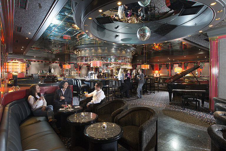 Gäste genießen Cocktails in der stilvollen Bar mit Klavier und eleganter Beleuchtung im Maritim Hotel Hannover.