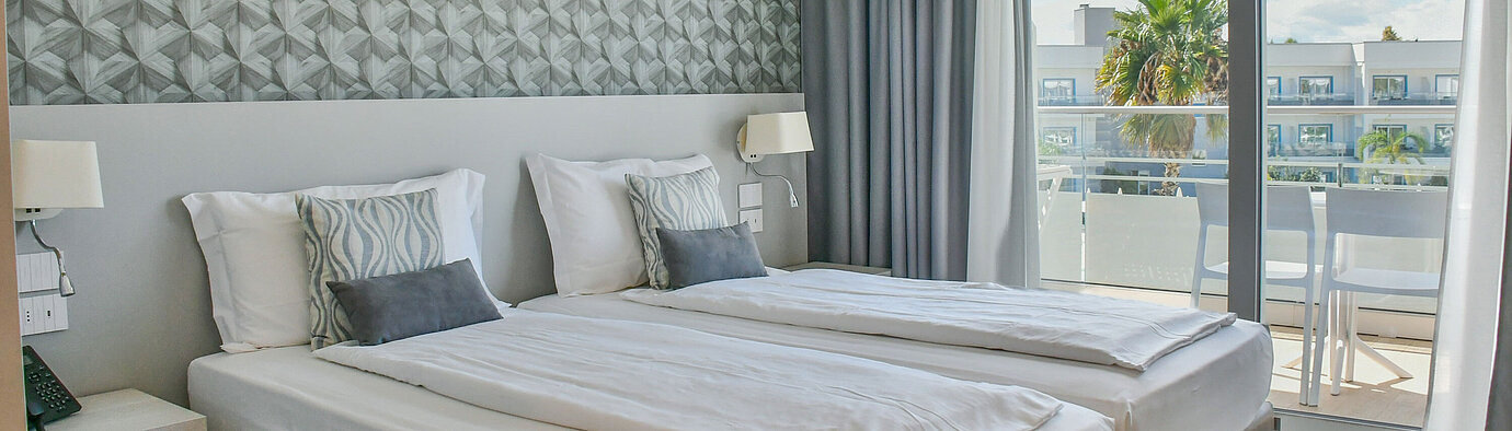 Doppelzimmer im Maritim Resort Calabria mit Balkon und Ausblick auf Palmen und Resortanlage