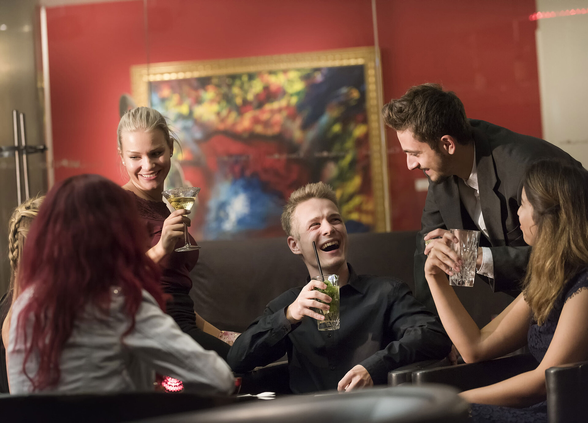 Gruppe von Gästen genießt Cocktails und lacht in der Bar des Maritim proArte Hotel Berlin.