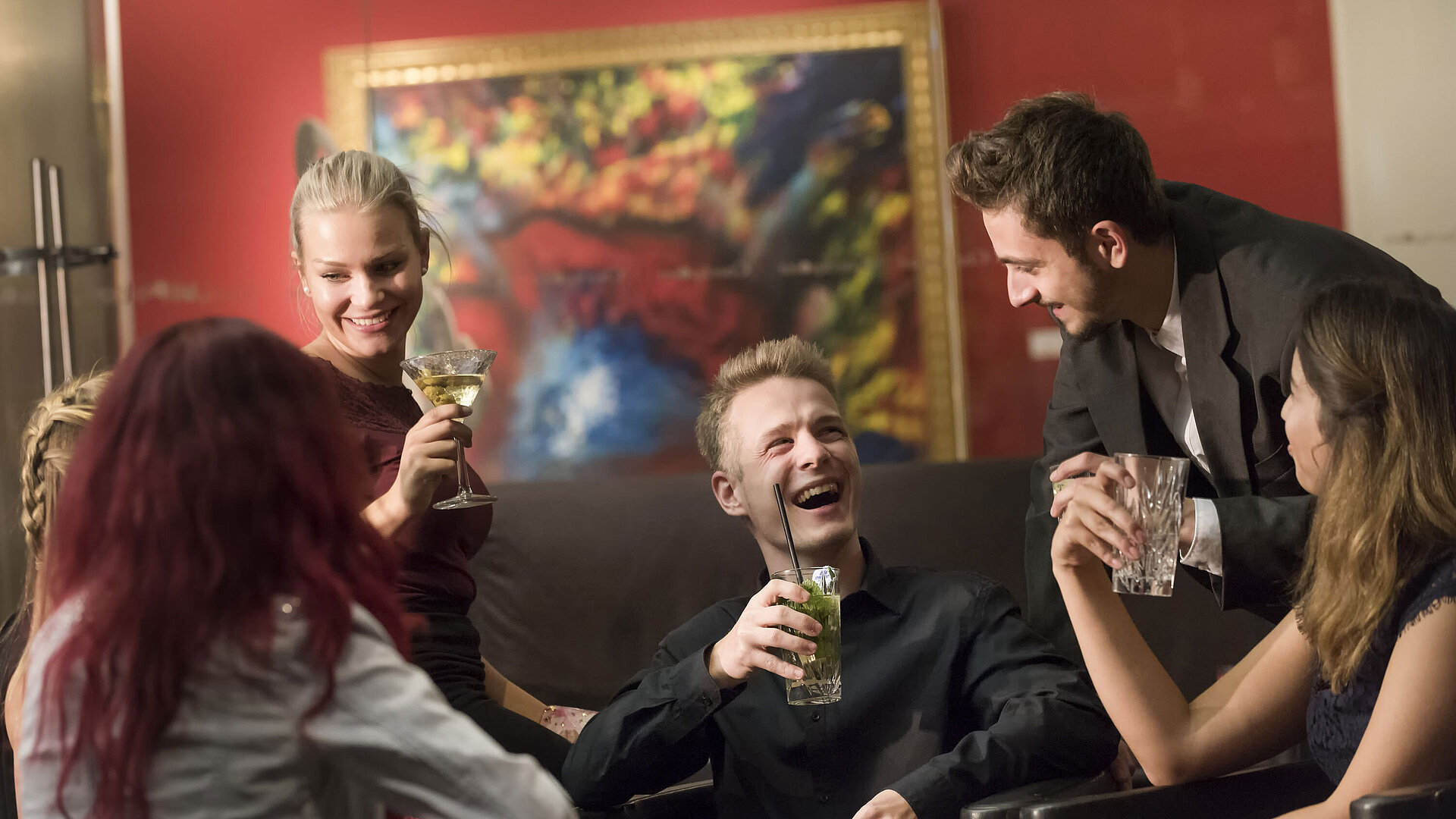 Gruppe von Gästen genießt Cocktails und lacht in der Bar des Maritim proArte Hotel Berlin.