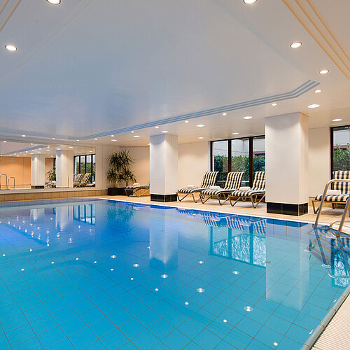 Modernes Hallenbad im Maritim Hotel Fulda mit Liegestühlen, großen Fenstern und entspannter Atmosphäre.