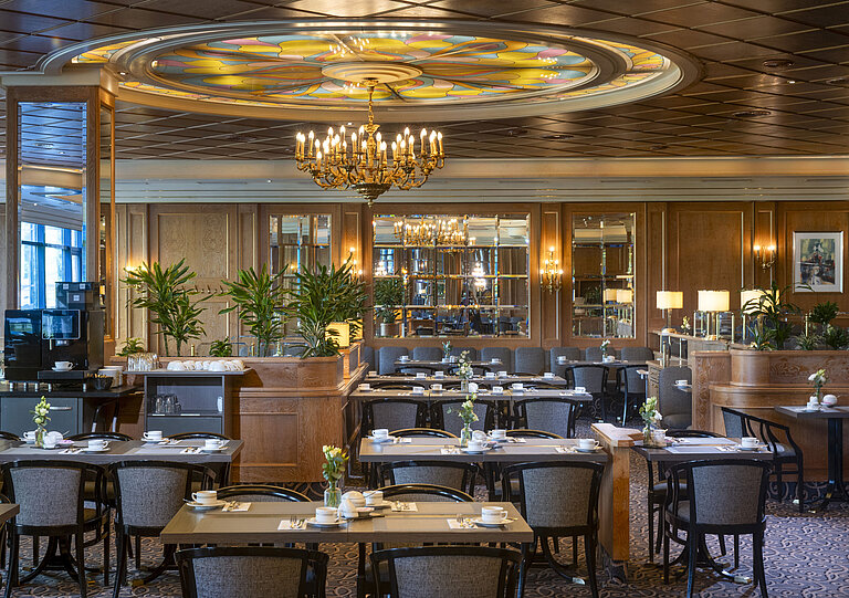 Stilvolles Restaurant im Maritim Hotel Hannover mit Kronleuchter und Glasdecke im Blumenmuster.