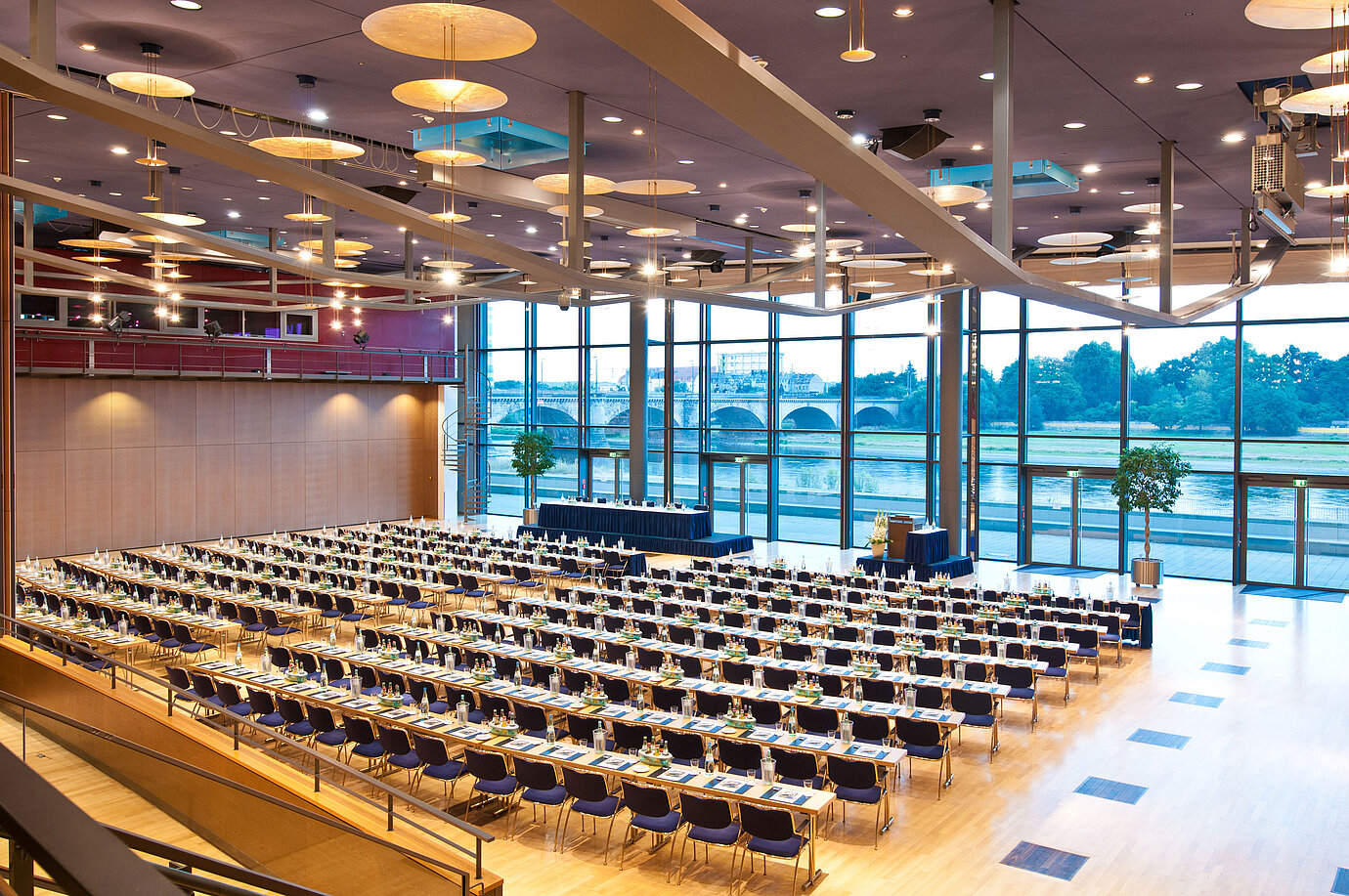 Großer Konferenzsaal im Maritim Hotel Dresden mit Reihen blauer Stühle und Blick auf die Elbe.