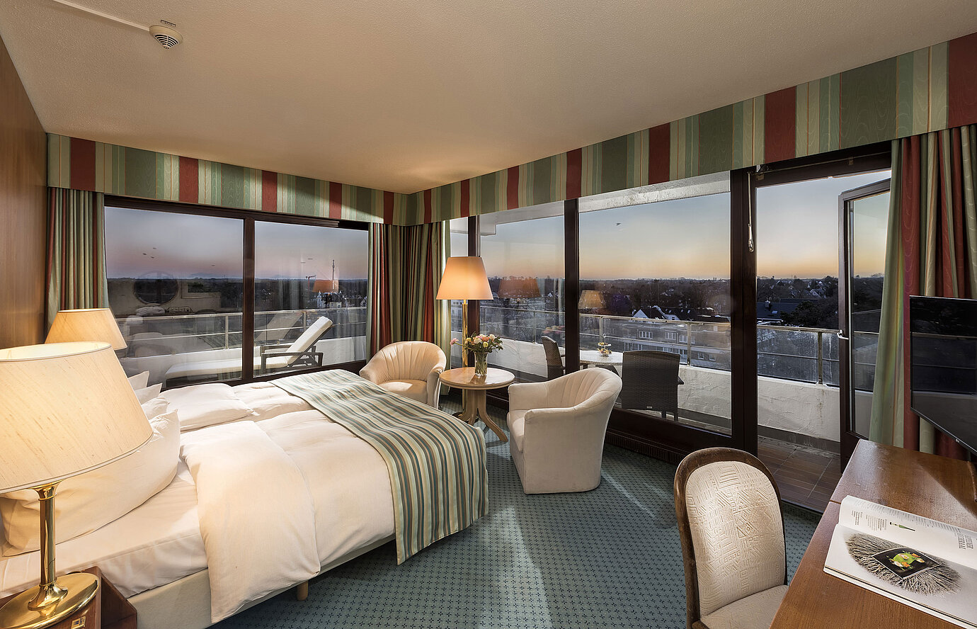 Superior Zimmer im Maritim Seehotel Timmendorfer Strand mit Meerblick, Doppelbett, Sitzecke und Balkon.
