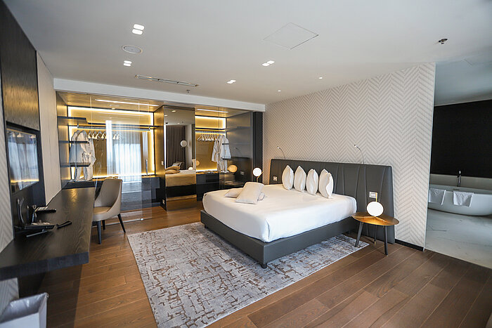 Design-Schlafzimmer mit großzügigem Bett, Spiegelwand und Ankleide im Maritim Hotel Plaza Tirana