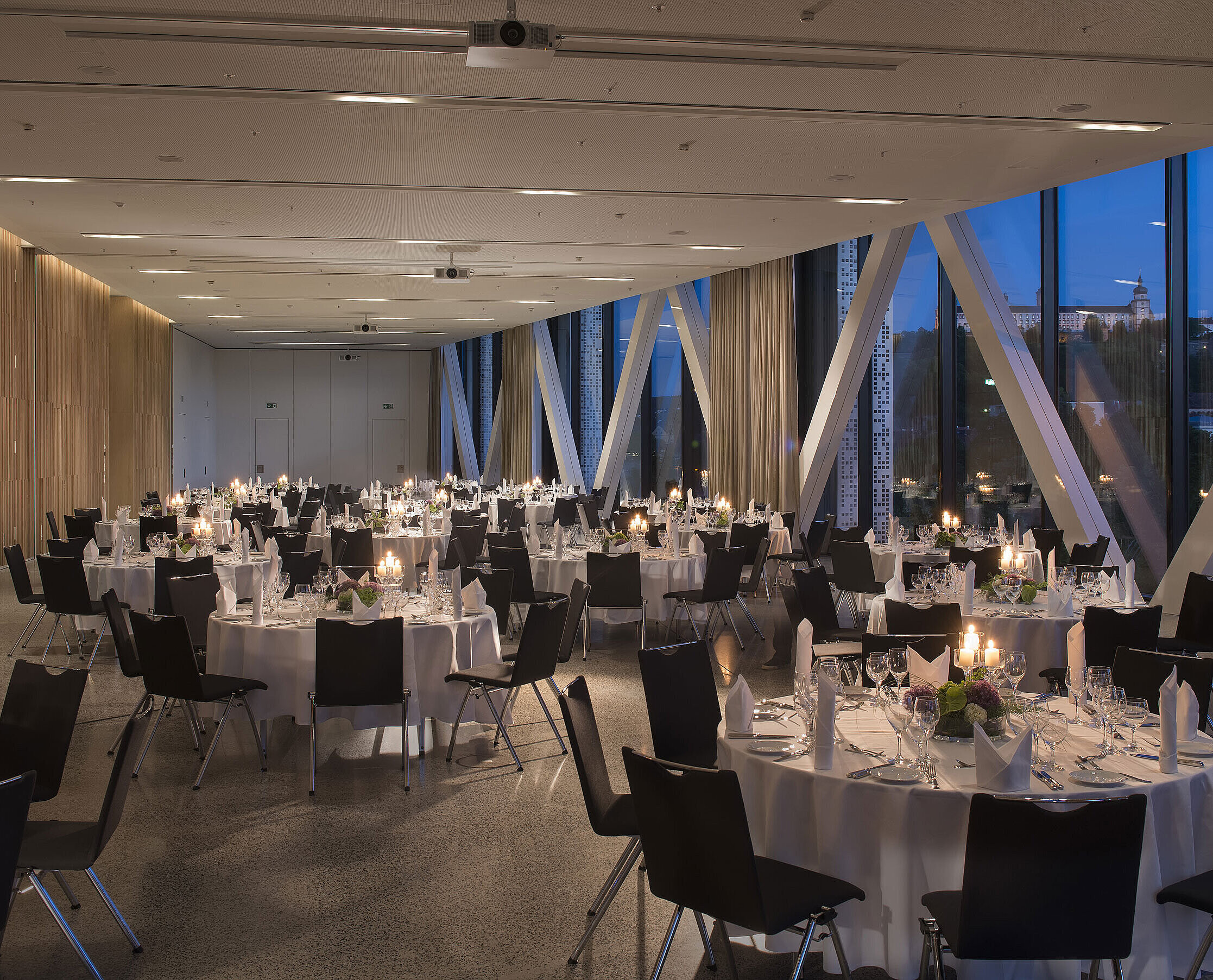 Eleganter Veranstaltungsraum im Maritim Hotel Würzburg mit runden Tischen und Blick auf die Festung