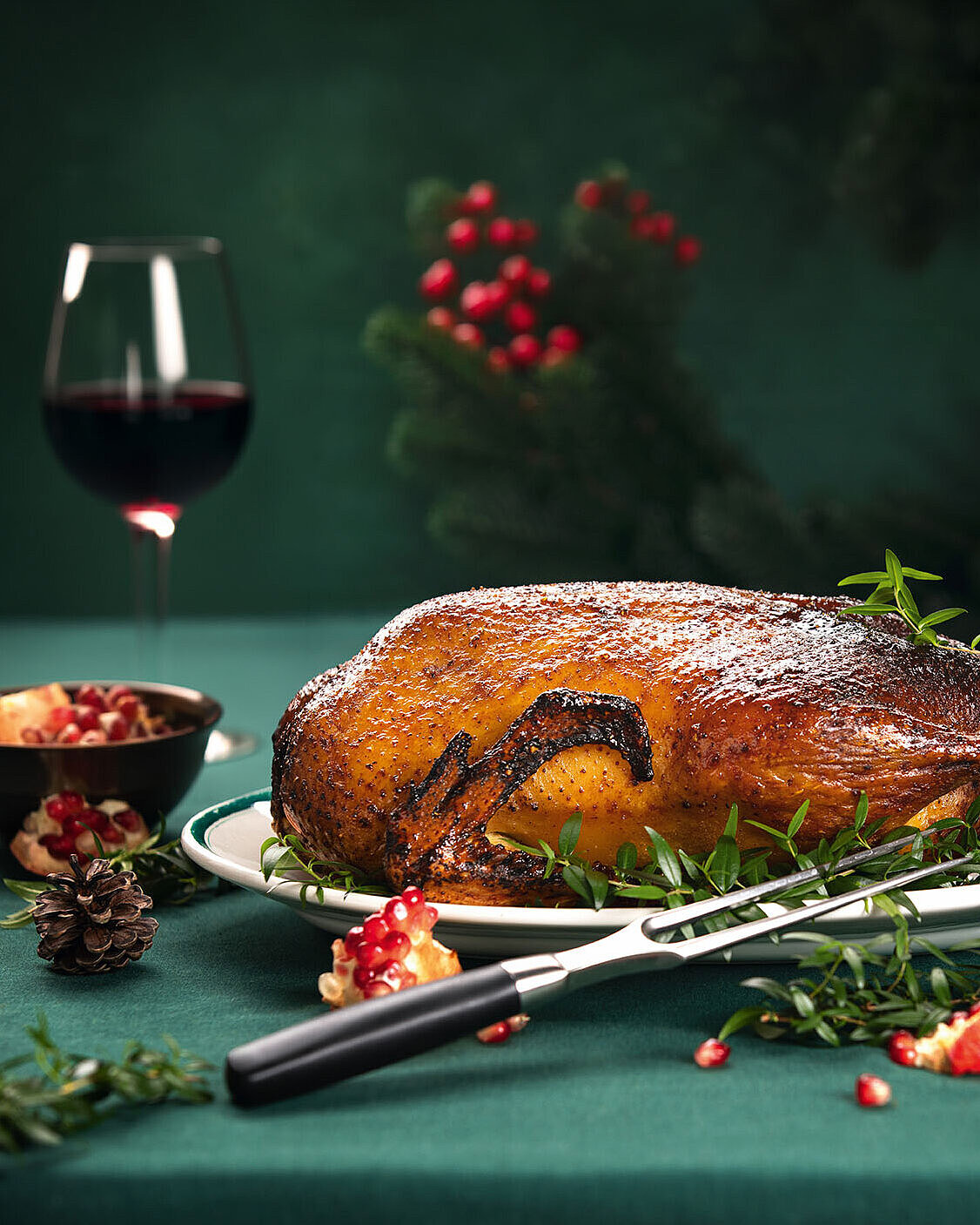 Festlicher Gänsebraten mit Rotwein und weihnachtlicher Tischdekoration