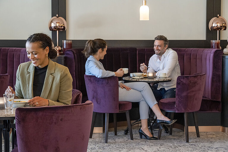 Gäste genießen eine gemütliche Kaffeepause in der stilvollen Lounge des Maritim Hotel Ingolstadt.